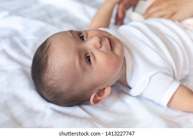 Angry 6 Months Old Baby In Bed. Little Baby Boy Feeling Uncomfortable And Unhappy. Free Space