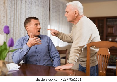 Angry adult man quarreling with his elderly father at home. Generation conflict concept.. - Powered by Shutterstock