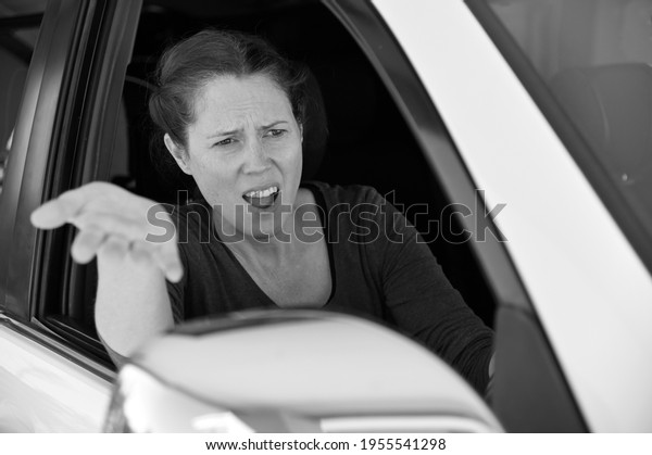 Angry adult woman (female age 30-40) driver
in a car screaming at traffic
conditions.