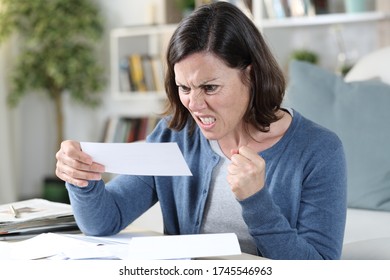 Angry Adult Woman Looking At Receipts Sitting In The Livingroom At Home