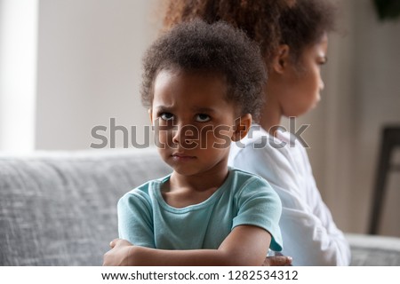 Angry african american little boy offended not talking ignoring black sister after fight, jealous kid brother sulking avoiding preschool girl, siblings bad relationships, two children conflict