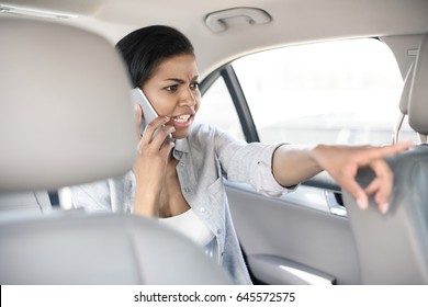 Angry African American Woman Using Smartphone In Taxi  