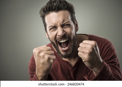 Angry aggressive man shouting out loud with ferocious expression