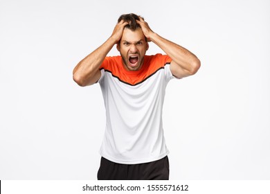 Angry, Aggressive Mascular Sportsman Looking Furious, Grab Head In Rage And Fury, Shouting And Grimacing From Anger And Disappointment. Athlete Lost Match, Team Scored Goal, White Background