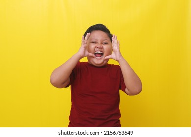 Angry Asian Boy Standing While Shouting Or Screaming. Isolated On Yellow Background