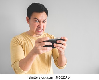 Angry Asian Man Plays Mobile Game On His Smartphone.