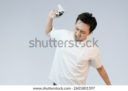 angry asian man throwing controller in studio background