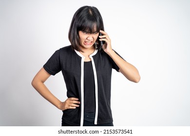 Angry Asian Woman Making A Call Using A Cell Phone On Isolated Background