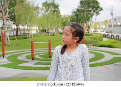 Angry Asian Young Girl Child And Looking Beside While Sitting In The Garden Outdoor