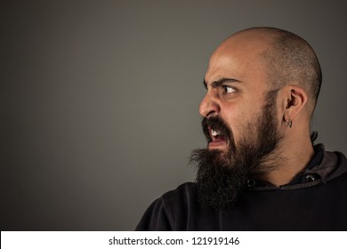 Angry bearded man looking at somebody and shouting