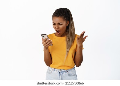 Angry Black Woman Arguing With Phone, Yelling At Smartphone With Frustrated Face, White Background