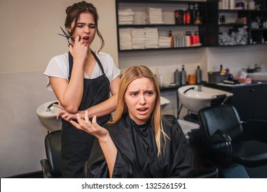 Angry Blonde Young Female Client Screaming At Hairdresser As A Haircut Done Bad. Fight In Beauty Salon