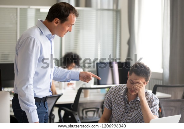 Angry boss ceo scolding rebuking incompetent\
office worker intern, dissatisfied team leader shouting pointing\
finger at lazy employee for bad work failure, reprimand or\
discrimination at work\
concept