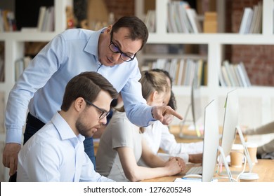Angry boss criticizing scolding sad male employee for computer mistake incompetence at workplace, mad leader reprimanding rebuking shouting at subordinate lazy worker blaming of bad work in office - Shutterstock ID 1276205248