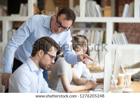 Angry boss criticizing scolding sad male employee for computer mistake incompetence at workplace, mad leader reprimanding rebuking shouting at subordinate lazy worker blaming of bad work in office Stock photo © 