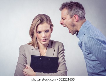 Angry boss screaming to his employer woman and she is surprised and shocked. Isolated on white background
