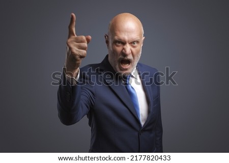 Angry boss shouting at camera, he is scolding an employee