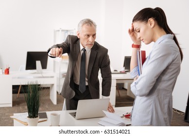 Angry boss standing opposite his secretary