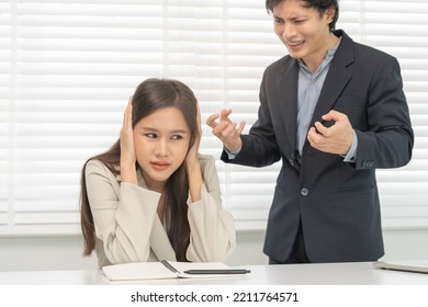 Angry Boss, Stressed Asian Young Business, Employee, Secretary Woman Sitting At Desk, Hand Cover Her Ears Feel Upset From Annoying Boss, Colleague Conflict With Manager Mistake About Job At Office.