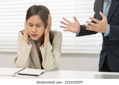 Angry Boss, Stressed Asian Young Business, Employee, Secretary Woman Sitting At Desk, Hand Cover Her Ears Feel Upset From Annoying Boss, Colleague Conflict With Manager Mistake About Job At Office.