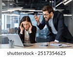 Angry boss yelling at stressed female office worker seated at desk with laptop and phone. Intense workplace conflict and frustration conveyed through facial expressions