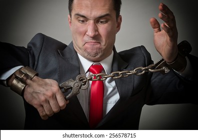 Angry Businessman Breaking The Shackles On His Hands