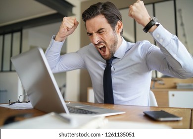 Angry Businessman Losing Patience And Screaming At Laptop In Modern Office