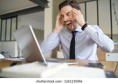 Angry Businessman Losing Patience And Screaming At Laptop In Modern Office