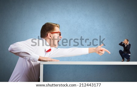 Angry businessman screaming at miniature of woman colleague
