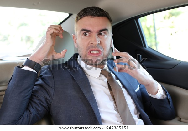 Angry businessman shouting\
in taxi