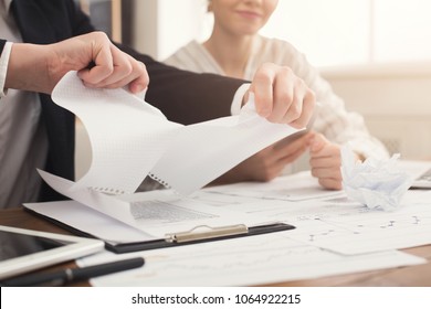 Angry businessman tearing up a document, contract or agreement in office, copy space. Closeup of man hands, selective focus