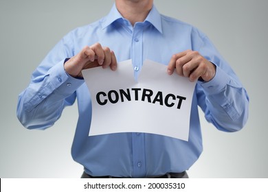 Angry businessman tearing up a document, contract or agreement