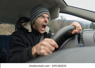 Angry Caucasian Man With Screaming Into Car In Winter Time. Stressed Man Into Vehicle Concept