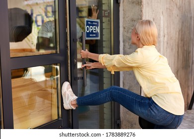 Angry Caucasian Woman Opens The Door With Her Foot, Young Blonde Lady After Quarantine, Worker Inside Of Cafe Looks At Her