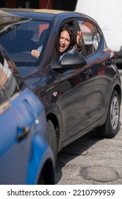 Angry Caucasian Woman Screaming And Pointing With Hand From Side Window While Driving Car