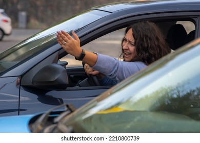 Angry Caucasian Woman Screaming And Pointing With Hand From Side Window While Driving Car