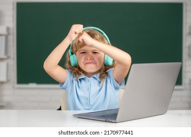 Angry Child Using Laptop Computer, Sad Excited Kid Boy Studying Through Online E-learning. Little Funny System Administrator.