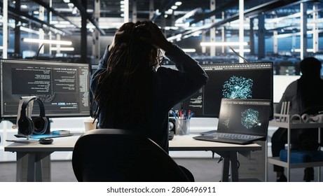 Angry computing hub software developer frustrated by slow data analytics AI generator, while annoyed server facility staff member punching desk, irked by buggy AI program showing system metrics.