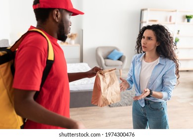 Angry Confused Woman Received Wrong Order Or Waited Too Long, Scared Male Courier Holding Package, Delivering Takeaway Food From Restaurant. Female Customer Complaining About Bad Service Or Delay