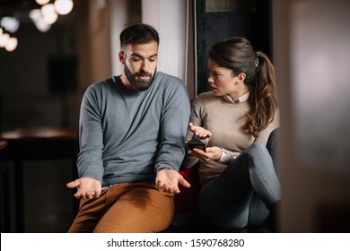 Angry couple or marriage fighting for a mobile phone at home.  Jealous caucasian woman holding smart phone and showing message to his husband - Powered by Shutterstock