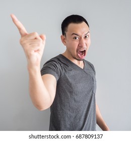 Angry And Crazy Asian Man In Black T-shirt And Skinhead Hair Style.