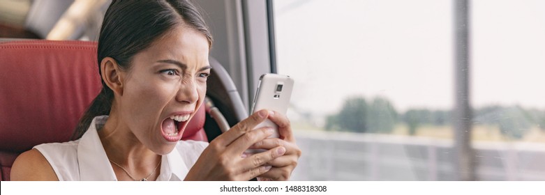 Angry crazy Asian woman upset at mobile phone problem not working or texting upset to somebody over smartphone 5g internet during work commute train ride panoramic banner. - Shutterstock ID 1488318308