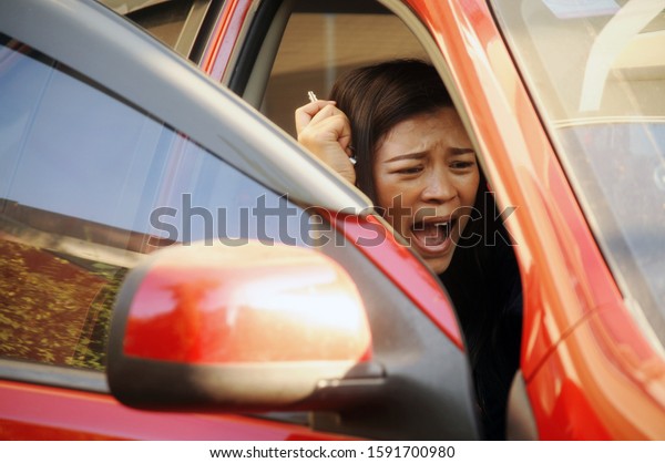 Angry and desperate woman having trouble with broken\
car. 