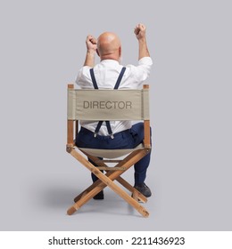 Angry Disappointed Film Director Sitting On The Director's Chair And Shouting With Raised Fists