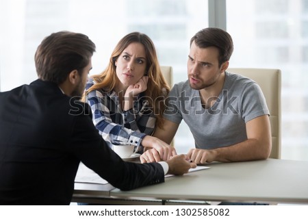 Angry dissatisfied couple arguing meeting lawyer or manager having legal fight complaints on bad client service, annoyed mad customers claiming change in contract terms demanding fraud compensation