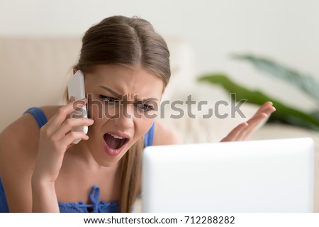 Angry dissatisfied young woman calling customer support or mobile banking, displeased client complaining about bad service, arguing on phone, having conflict during telephone conversation at home