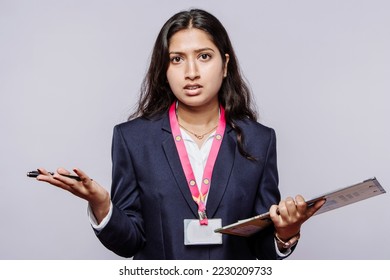 Angry distressed millennial Indian female employee looking at the camera frustrated by a latecomer or a problem. Unhappy young ethnic woman shocked and stressed by sales report.