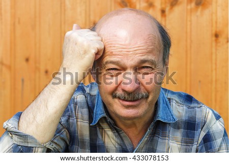 Angry elderly man knocks himself on the head with his fist.  teach the mind to reason.