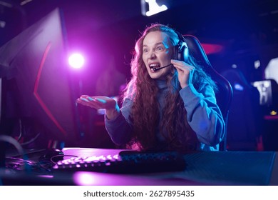 Angry Excited young woman gamer playing in video game and streaming in high-tech gaming setup with headset.
