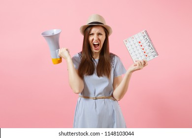 Angry expression wild woman screaming in megaphone, holding periods calendar for checking menstruation days isolated on pink background. Medical healthcare, pms mood gynecological concept. Copy space